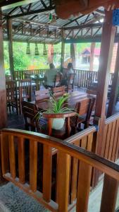ein Restaurant mit Tisch und Stühlen und Menschen im Hintergrund in der Unterkunft Leuser Inn & Jungle Trekking in Bukit Lawang + 22 Fotos