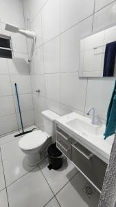a white bathroom with a toilet and a sink at Casa aconchegante em Horizonte-CE! in Horizonte +8 photos