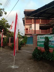 a red and white flag in front of a building at Penginapan ANGLING DARMA in Cidaun