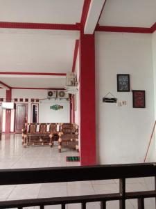 a room with chairs and a red and white wall at Penginapan ANGLING DARMA in Cidaun