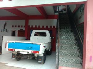 a white truck parked inside of a garage at Penginapan ANGLING DARMA in Cidaun