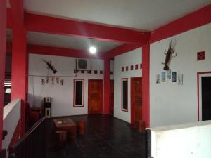a room with red and white walls and a room with antlers at Penginapan ANGLING DARMA in Cidaun