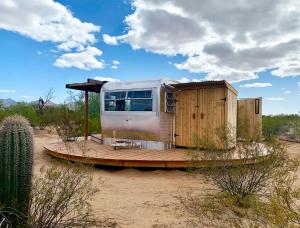 an old rv sitting on a wooden deck in the desert at The Island in Tucson in Tucson