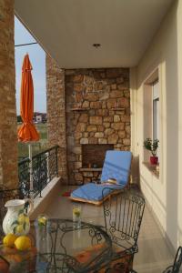 a patio with a blue chair and a fireplace at Infinite blue Horizon Elegance Hospitality in Epanomi