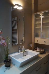 a bathroom with a white sink and a mirror at Infinite blue Horizon Elegance Hospitality in Epanomi
