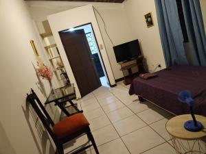 a bedroom with a bed and a table and a television at Cata Bed Breakfast Pet-friendly in San José