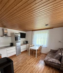 a kitchen and a living room with a wooden ceiling at Ferienhaus Rafaela mit Privatstrand in Ledenitzen