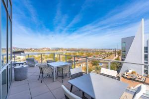 a balcony with tables and chairs on a building at Olive Oasis Retreat - Walkout to Pool & Hot Tub! in Tempe Junction