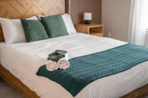 a bed with two towels on top of it at Olive Oasis Retreat - Walkout to Pool & Hot Tub! in Tempe Junction +18 photos