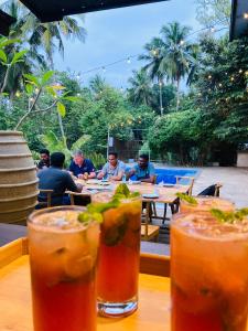 a group of people sitting at a table with drinks at Motel Vintage Beliatta in Beliatta