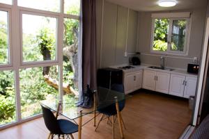 a kitchen with a glass table and chairs and windows at Casa Abitare Armonía in Isla de Mezcala
