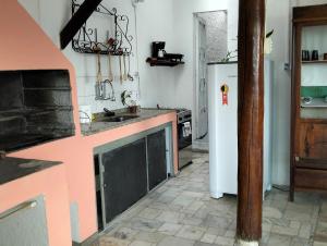 eine Küche mit einem weißen Kühlschrank und einem Herd in der Unterkunft Casa gourmet vista para o mar in Ilhabela + 21 Fotos