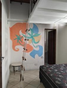 Zimmer mit einem Bett und einer Wand mit einem Gemälde in der Unterkunft Casa gourmet vista para o mar in Ilhabela