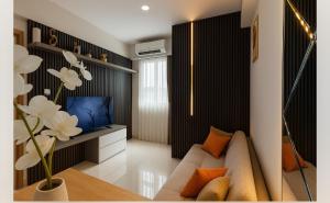a living room with a couch and a tv at Corner High floor 2BR apartment Batam in Nagoya