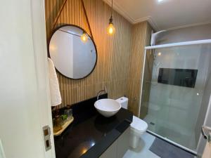 une salle de bain avec un lavabo et un miroir dans l'établissement Apartamento Cobertura em Guarajuba Perto do Mar, à Camaçari 25 autres photos
