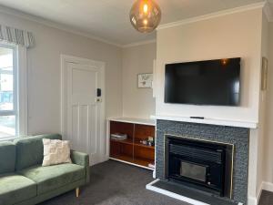 a living room with a fireplace with a flat screen tv at Cottage on Duke in Cambridge