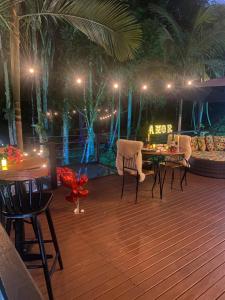 a wooden deck with chairs and a table at night at Cabana Arpuro in Santo Amaro da Imperatriz