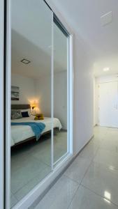 a bedroom with a bed and a large glass window at Las Mareas Sea View Terrace 3 min to Beach in Morro del Jable