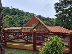 a house with a wooden fence in front of it at Villa Faris in Los Altos de Cerro Azul