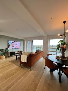 a living room with a couch and a table at Saya Homes - Modern 70m2 apartment in Jessheim