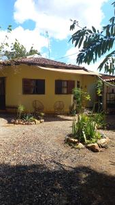 a yellow house with two chairs in front of it at Casa Solar in Sao Jorge