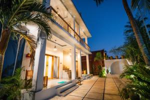a house with a courtyard with palm trees at Penida Green Palm Cottage in Nusa Penida