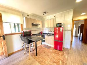 フルティジャールにあるApartHotel Cuatro Estaciones Frutillar Bajoのキッチン(赤い冷蔵庫、テーブル付)