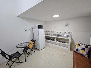 a kitchen with a refrigerator and a table and chairs at Loft Nicolau Garcia in São José +18 photos