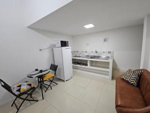 a kitchen with a refrigerator and a table and chairs at Loft Nicolau Garcia in São José