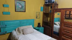 a bedroom with blue cabinets and a bed and a book shelf at Habitación estilo vintage cerca de La Merced in Antigua Guatemala