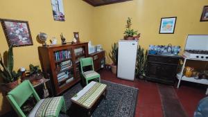 a living room with green chairs and a refrigerator at Habitación estilo vintage cerca de La Merced in Antigua Guatemala
