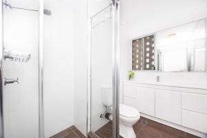 ein Badezimmer mit Toilette und Glasdusche in der Unterkunft El Sandi, Unit 10, 14-18 North Street in Forster + 17 Fotos