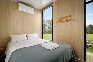 a bedroom with a bed with towels on it at High on a Mountain Top by Tiny Away in Koornalla