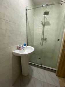 a bathroom with a sink and a glass shower at 2 bedroom duplex apartment in Ibadan +5 photos