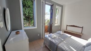 ein kleines Schlafzimmer mit einem Bett und einem Fenster in der Unterkunft Casa com mini floresta, a paz ao lado do Centro in Rio de Janeiro