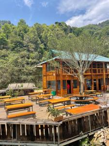 a building with wooden benches in front of it at Hoa Núi 2 Homestay Tà Xùa in Bắc Yên