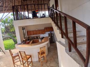 a staircase leading to the kitchen and living room of a house at Seasoul Sanctuary in Shimoni