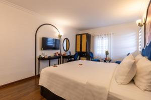 a hotel room with a white bed and a mirror at Hanoi House Hotel & Travel in Hanoi