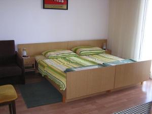 a bedroom with a large bed with a wooden frame at Apartments Vorkapic in Šilo