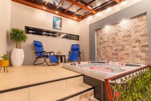 a jacuzzi tub in a room with blue chairs at Cabinas JS in Coto Brus