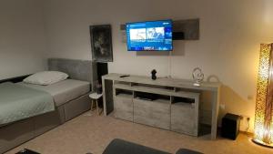 a bedroom with a bed and a television on the wall at Pension Winter Obergeschoss in Senftenberg
