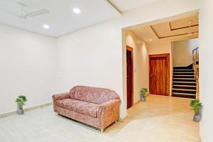a chair in a living room with a staircase at FabHotel Adiyogi Aura in Indore