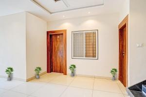 an empty room with a door and two potted plants at FabHotel Adiyogi Aura in Indore +19 photos