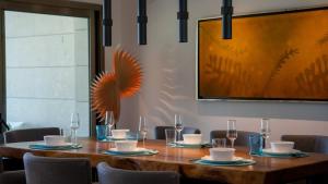 a wooden table with chairs and a large painting on the wall at 3BR Beachfront Luxury Condo w/ Great Features in Cancún