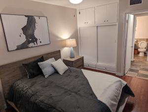 a bedroom with a large bed and a lamp at STADIUM LUXURY - CONDO for 4 STEPS AWAY FROM SOFI in Inglewood