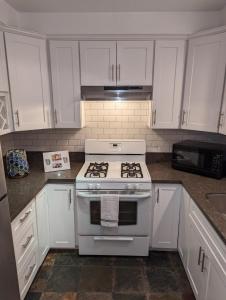 a kitchen with a white stove and white cabinets at STADIUM LUXURY - CONDO for 4 STEPS AWAY FROM SOFI in Inglewood