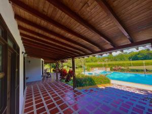 a patio with a wooden ceiling and a swimming pool at Hotel Campestre Jardin Cafetero Quindio in Armenia