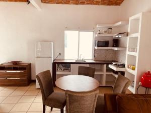 a kitchen with a table and chairs and a refrigerator at Casa Arena in Lo de Marcos