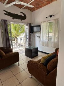 a living room with two couches and a lizard on the wall at Casa Arena in Lo de Marcos