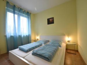 a bedroom with a bed with blue pillows on it at Ferienhaus in Zierow in Zierow